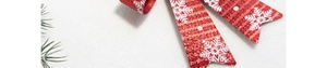 Close-up of red Christmas bow with white glitter snowflakes on a pine branch background