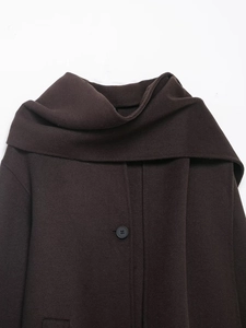 Detail of dark brown wool coat featuring a scarf collar and a single black button closure