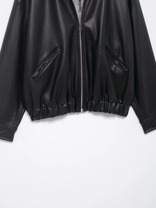 Detailed close-up of the black PU leather jacket featuring elastic hem and zipper