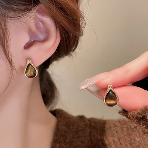 Close-up of vintage waterdrop earrings with brown tiger eye stones in gold setting