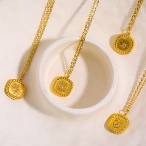 Gold tarot card necklaces featuring sun, moon, eye, and heart pendants with small crystals