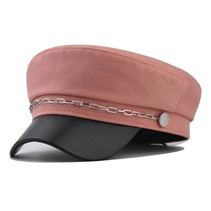 Détail de la casquette rose avec visière en cuir noir et chaîne en métal argenté