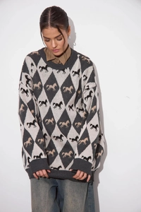 Macro view of oversized knit sweater featuring argyle patterns and horse jacquard details