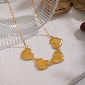 Collana vintage dorata con pendenti a cuore su pietra bianca in stile elegante