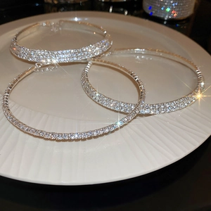 Detailed close-up of three luxury silver necklaces with sparkling pave diamonds