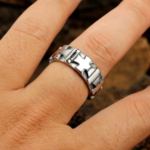 Close-up detail of vintage silver metal ring featuring carved geometric cross patterns