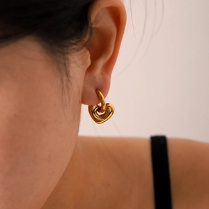 Orecchini a cuore in acciaio inossidabile placcato oro 18K indossati da una modella