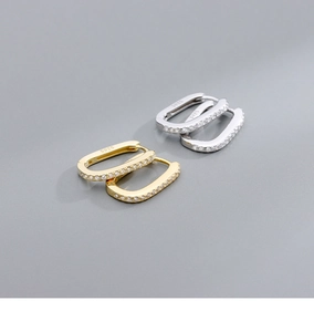 Macro shot of S925 sterling silver stamp on crystal-encrusted gold and silver U-shaped earrings