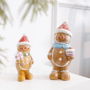 Resin Christmas gingerbread man figurines with candy canes and striped hats on white steps