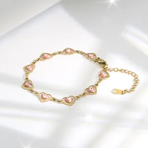 Macro detail of heart-shaped evil eye links and lobster clasp on gold plated bracelet