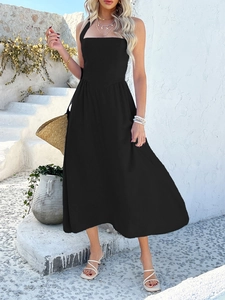 Detail of elegant black sleeveless halter neck maxi dress with straw bag and summer sandals
