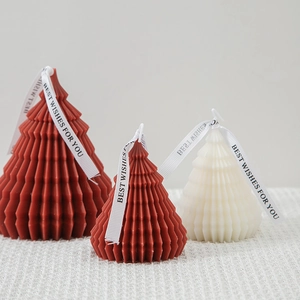 Three origami Christmas tree candles in red and white colors with decorative ribbons