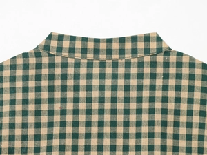 Detail of green plaid shirt neckline showing stitching and cotton fabric texture