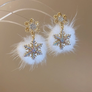 Detail view of snowflake earrings with sparkling rhinestones and white fur balls