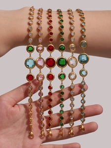 Detail of 18k gold-plated stainless steel bracelets with multi-colored glass gemstones