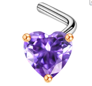 Macro view of heart-shaped purple zircon nose stud with golden 3-prong setting detail