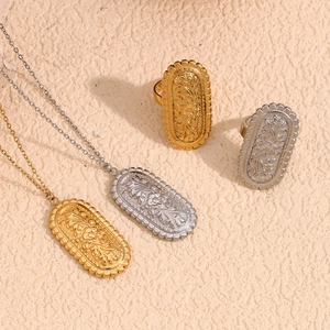 Detail of vintage floral embossed oval necklace and ring set in gold and silver finish
