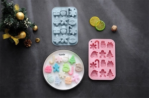 Detailed view of pink and grey silicone Christmas molds for snowman and gingerbread man treats
