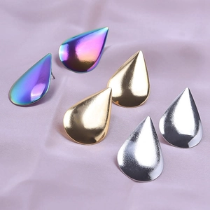 Detailed view of polished teardrop earrings in rainbow, gold, and silver finishes
