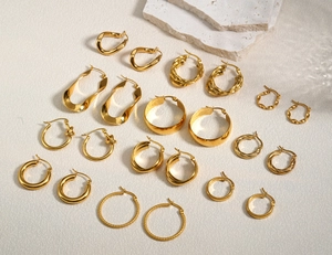 Detailed flat lay of 10-piece gold geometric earring set on white marble surface