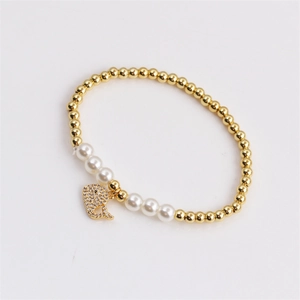 Golden bead bracelet featuring white pearls and a sparkling dolphin pendant for women