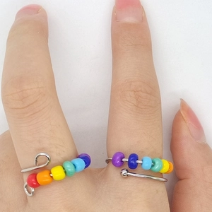 Close-up of rainbow bead spinner ring with adjustable silver band for stress relief