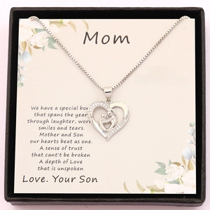Macro shot of silver heart-shaped necklace with mother and child pendant in gift box