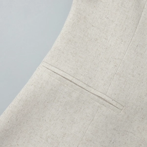 Detailed view of the linen texture and fine welt pocket stitching on the beige skirt set