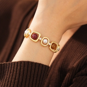 Bracelet vintage avec cadres carrés dorés et perles colorées porté au poignet