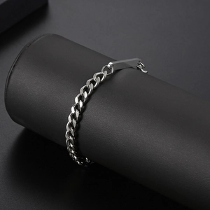 Macro shot of a silver titanium steel chain bracelet with rectangular tag on a black stand