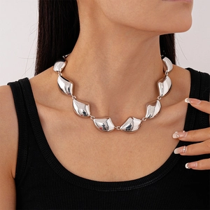 Dettaglio di perle metalliche argentate irregolari su una collana girocollo audace