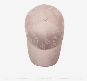 Draufsicht auf rosa Baseballkappe mit floraler Jacquard-Stickerei und feiner Stoffstruktur