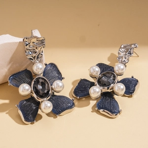 Macro detail of retro floral resin earrings with faux pearls and blue petals