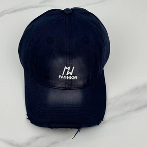 Close-up of MW FASHION embroidery and distressed brim on navy cotton baseball cap