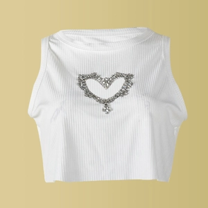 Détail d'un crop top blanc côtelé avec découpe en forme de cœur ornée de strass brillants