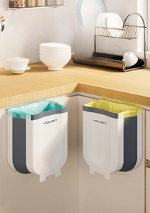 Detail of wall-mounted folding kitchen bins for waste sorting on cabinet door