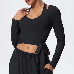 Close-up of black V-neck yoga top with cross strap design and slim-fit athletic fabric