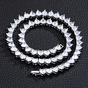 Close-up of silver tennis chain necklace with heart-shaped cubic zirconia on black leather
