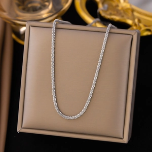 Elegante silberne Edelstahlhalskette mit Sternenkette auf einer beigen Geschenkbox