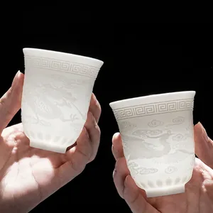 Translucent Dehua white porcelain tea cups with embossed dragon and phoenix patterns
