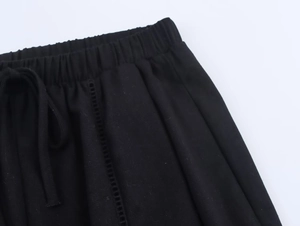 Detail of black linen trousers showing elastic waistband with adjustable drawstring