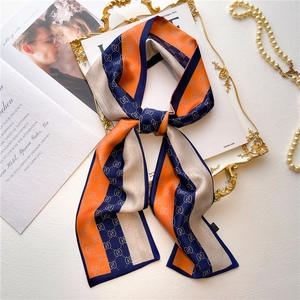 Foulard étroit en soie orange et bleu marine avec monogramme sur un plateau doré