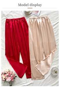 Détail de pantalons de détente en satin rouge et champagne avec taille élastique et décor
