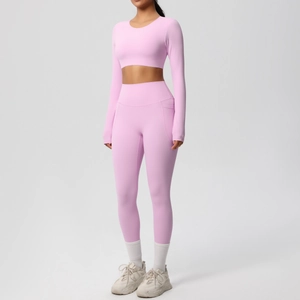 Detail of high-waist pink yoga leggings with side pockets and long sleeve crop top