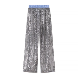 Détail du pantalon à paillettes argentées avec une taille élastique rayée bleue chic