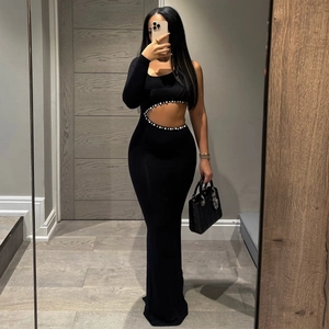 Détail de la découpe à la taille avec perles blanches sur une robe noire asymétrique