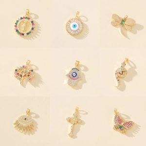 Detailed close-up of nine gold pendants featuring evil eye, dragonfly, and tree of life motifs