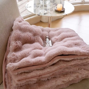 Detail of plush faux fur blanket in dusty pink with soft texture and cozy home decor