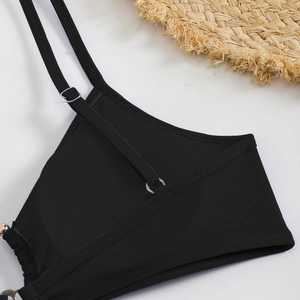 Detail of black halter bikini top with fine ribbed texture and silver metal adjusters