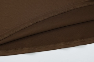 Dettaglio macro del tessuto a maglia marrone scuro con cuciture a doppio ago
